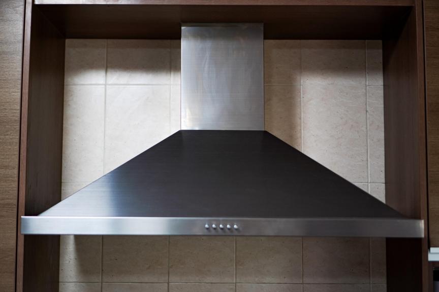 A close-up picture shows a wall-mounted electric chimney hood in a kitchen.