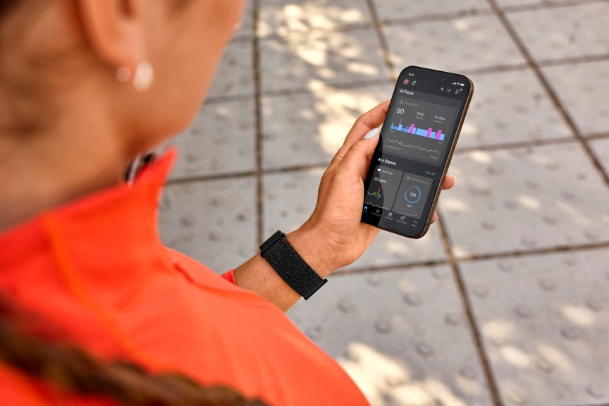 A hand holding a smartphone open to the Garmin Connect app.