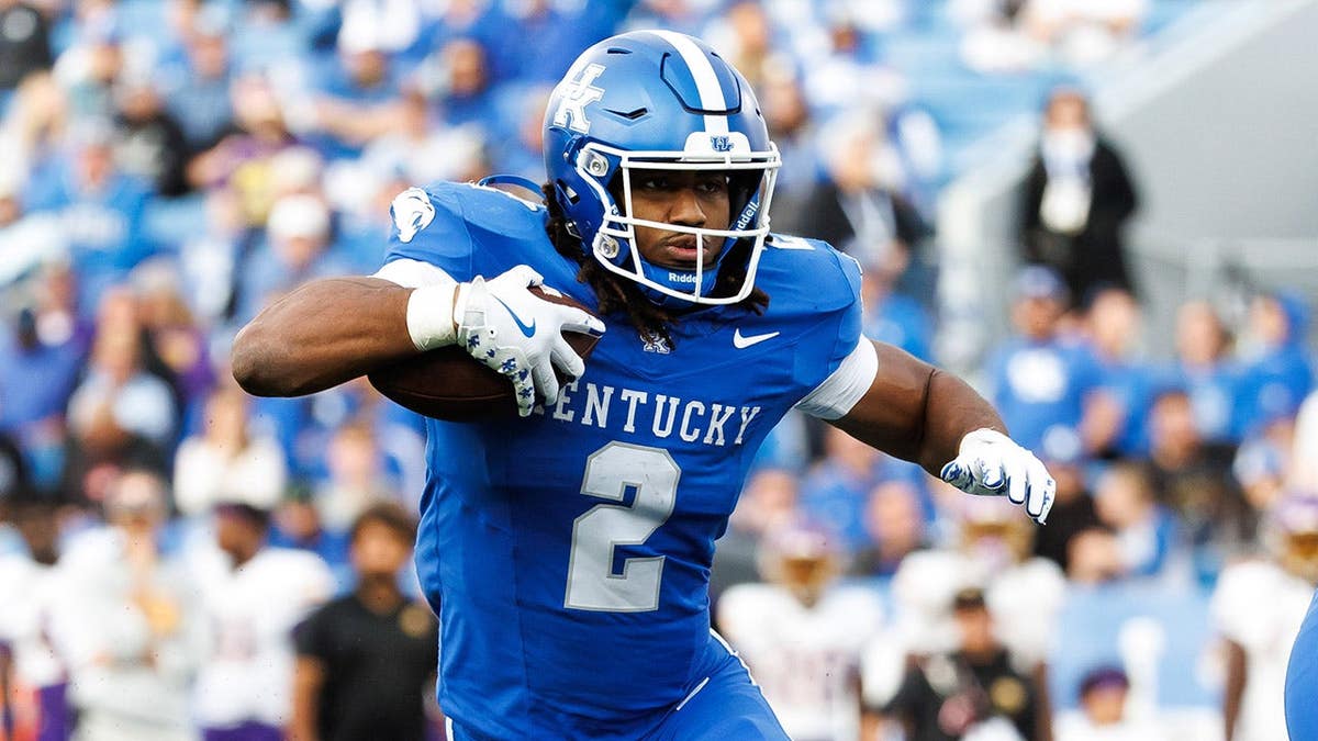 Dante Dowdell runs with the ball during a football game at Kroger Field.