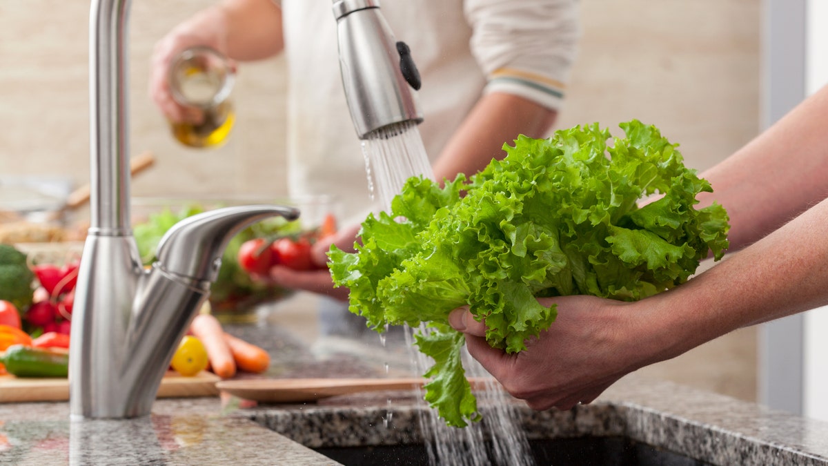 Washing fresh vegetables for a salad with an alive oil