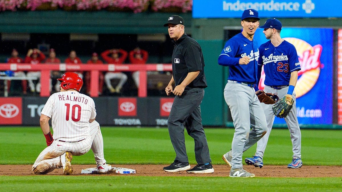 Tommy Edman tags J.T. Realmuto out at second base during a Dodgers-Phillies game.