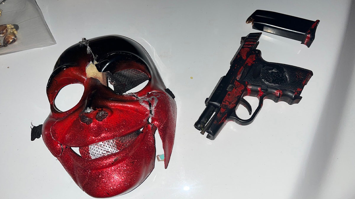Red mask and handgun displayed