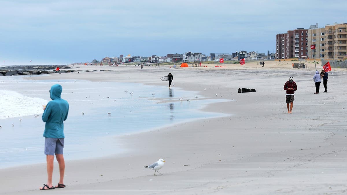 People walk along the beach.