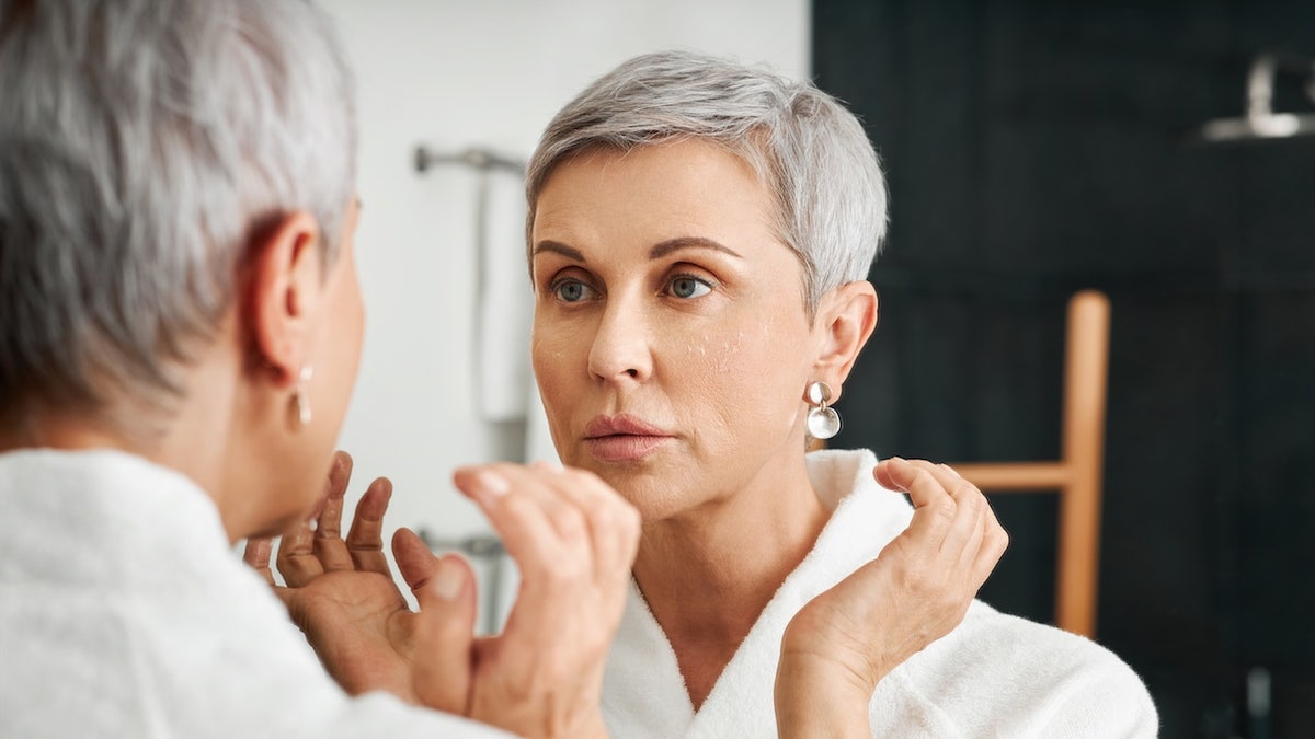 Stressed woman looking in mirror