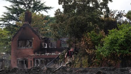 UK must ‘face up to changing climate’ as visits fire-hit town, PM says