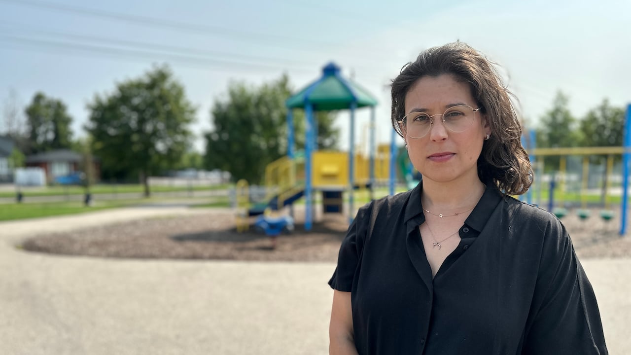 A portrait of a young woman with shoulder-length hair in front of a play structure.