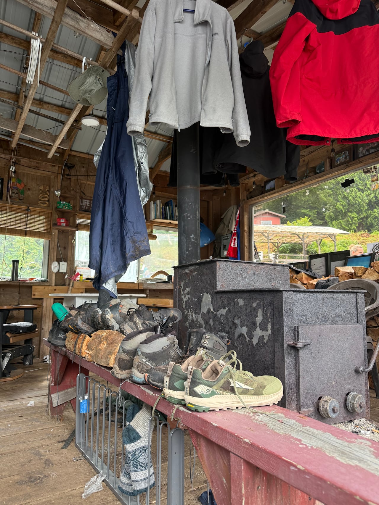 hiking gear hanging by a woodstove