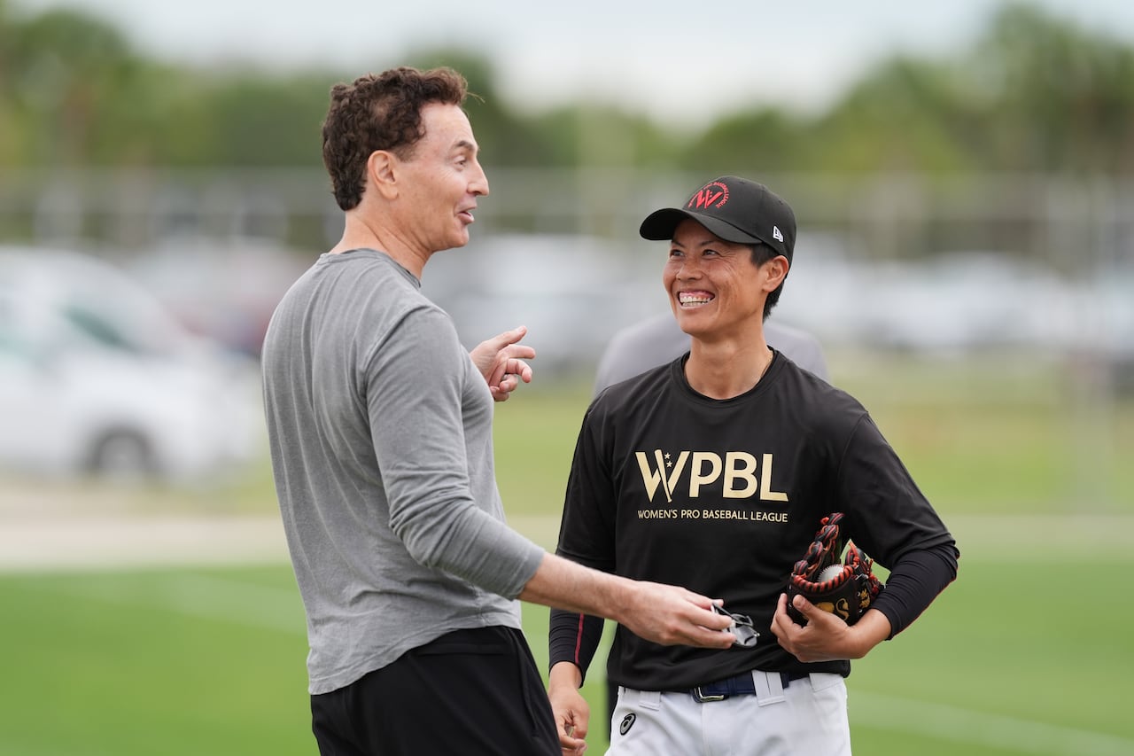 Keith Stein, the Canadian co-founder of the WPBL and pitcher Ayami Sato chat during a practice in Fort Myers, Fla.