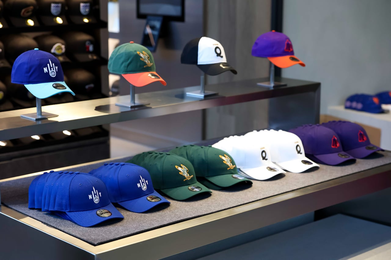 Hats on display featuring the logos of the four teams of the Women's Pro Baseball League.