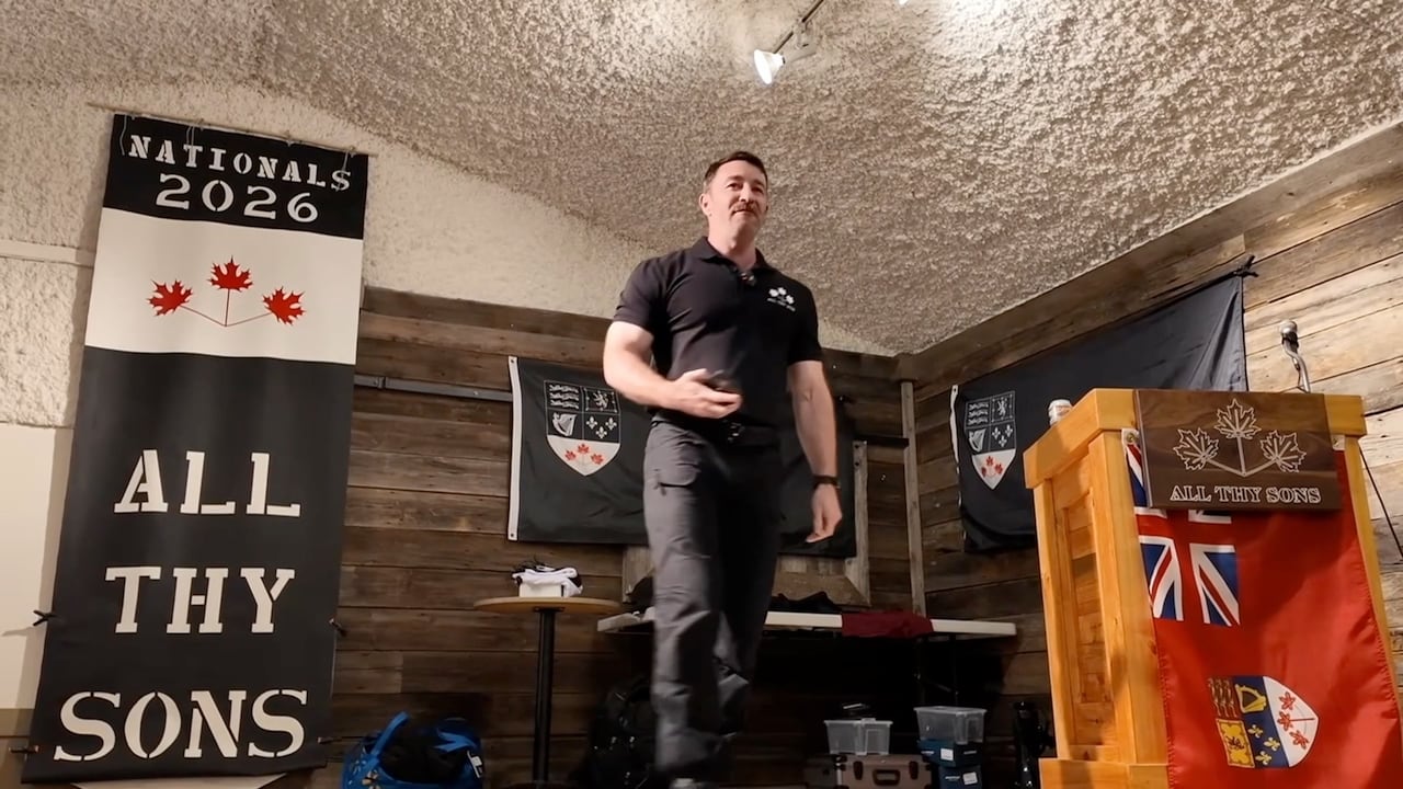 A man stands on a small stage and makes a speech.