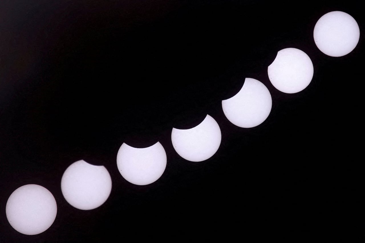 A composite of seven images of the sun showing various phases of a partial eclipse.
