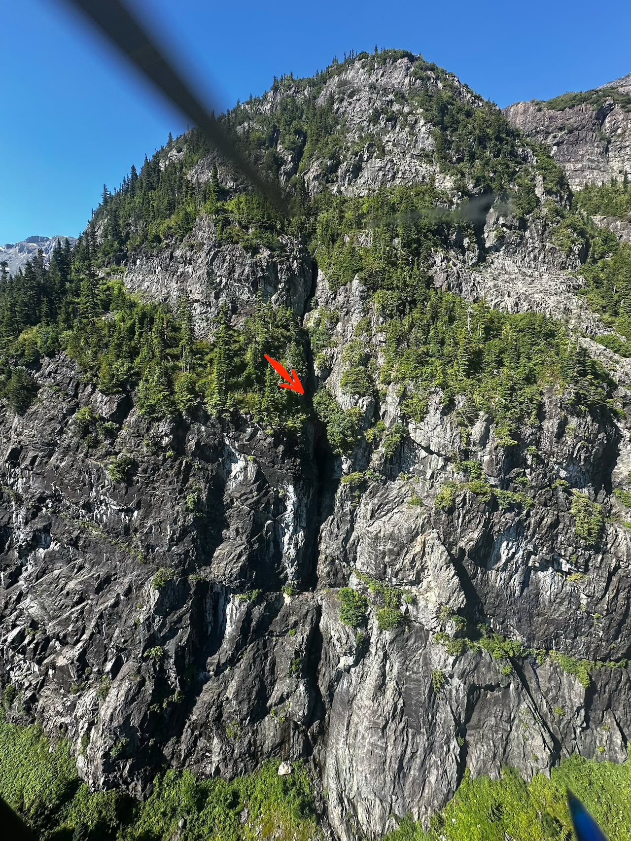 A photo shows a steep cliff with an arrow pointing in the middle.