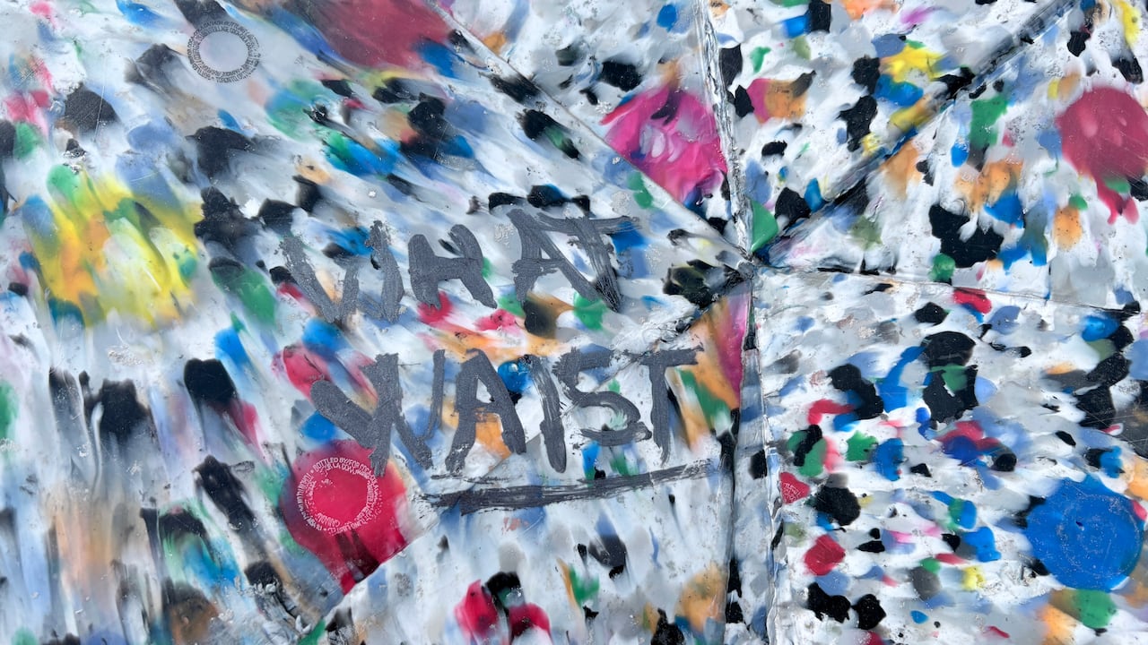 A close-up of a plastic sculpture shows "what waist" but probably intended to say "what waste".