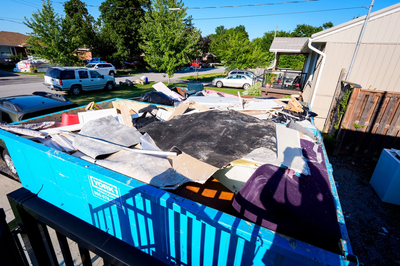 Residents of St. Catharine’s, Ont., clear written-off basements on Aug., 4, 2026 after a pair of flood events caused damage to thousands of homes in the city’s north end.