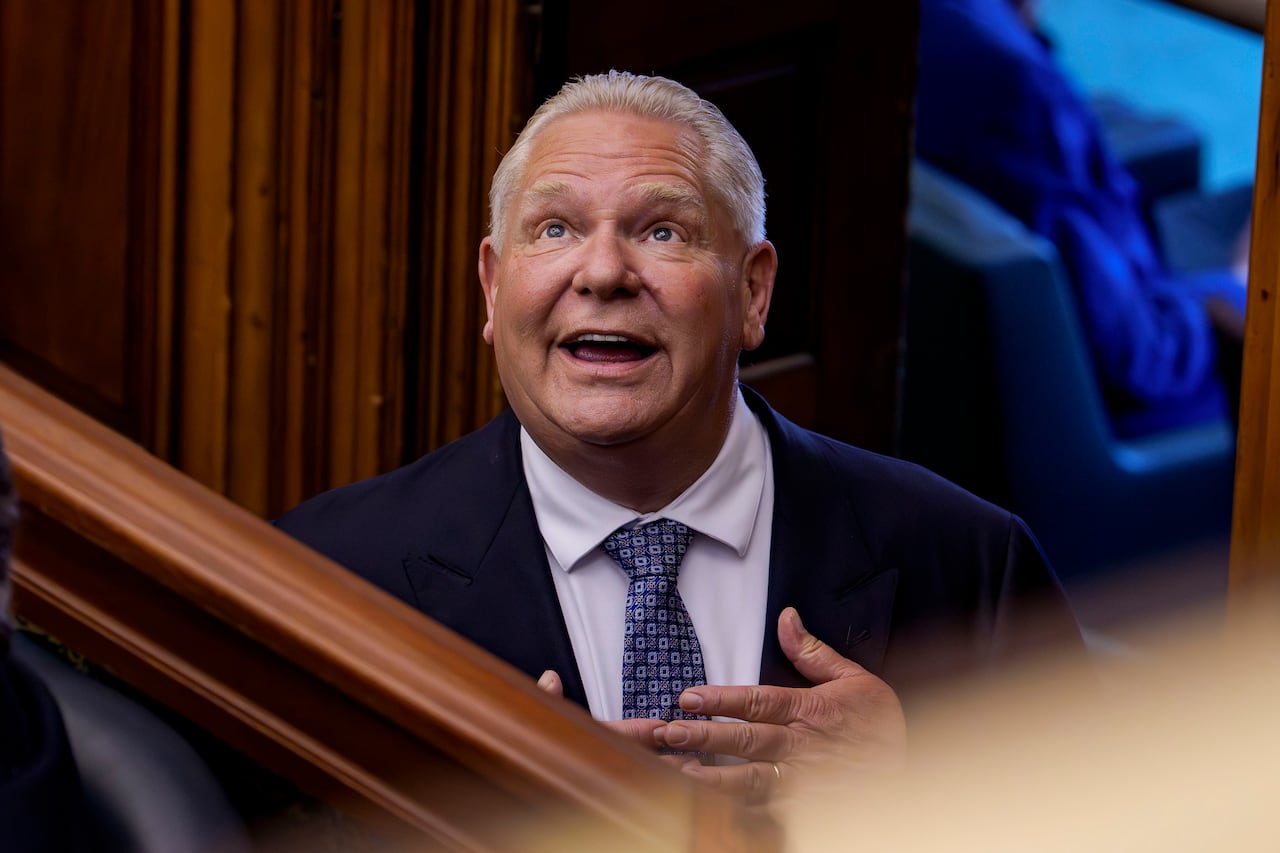 A man with blond hair is looking up. He's wearing a suit.
