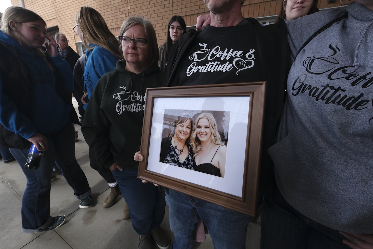 Family standing outside the provincial court on Friday hold a picture of Laura and Jamie Hannah