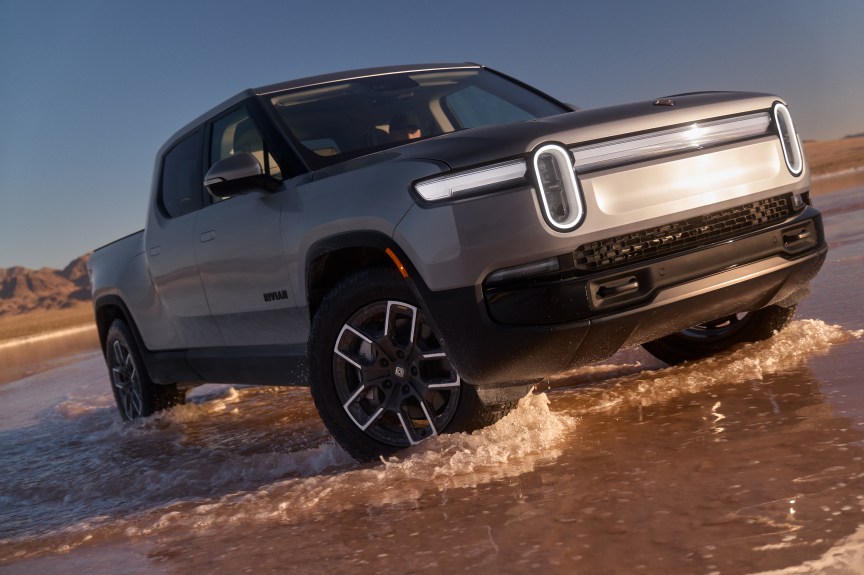 Rivian R1T crossing shallow water showcasing the new Silver Esker standard paint
