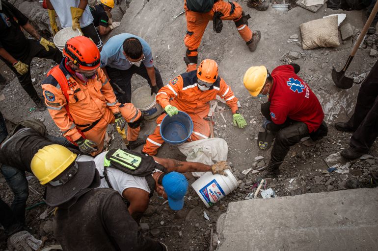 Rescuers attempt to locate survivors beneath the rubble of a collapsed apartment block close to Refugio Park, Cali. [Euan Wallace / Al Jazeera]