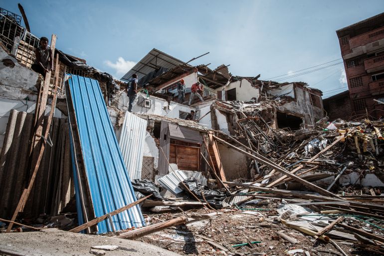 A row of houses that have been partially crushed by a falling building in Buenaventura. [Euan Wallace / Al Jazeera]