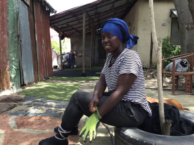 Fatou prepares for a day of crab harvesting, pulling on her gloves before venturing into the mangrove forest