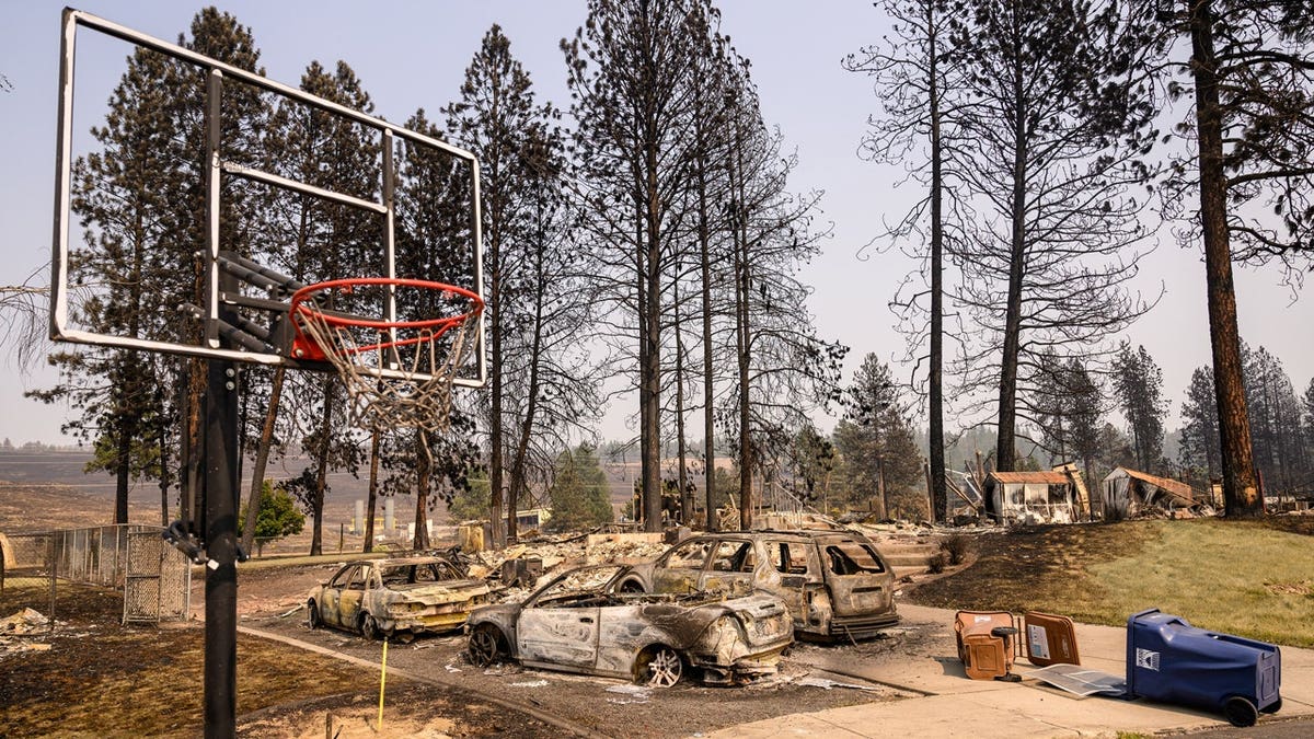 Home smolders during Old Trails fire in Spokane, Washington