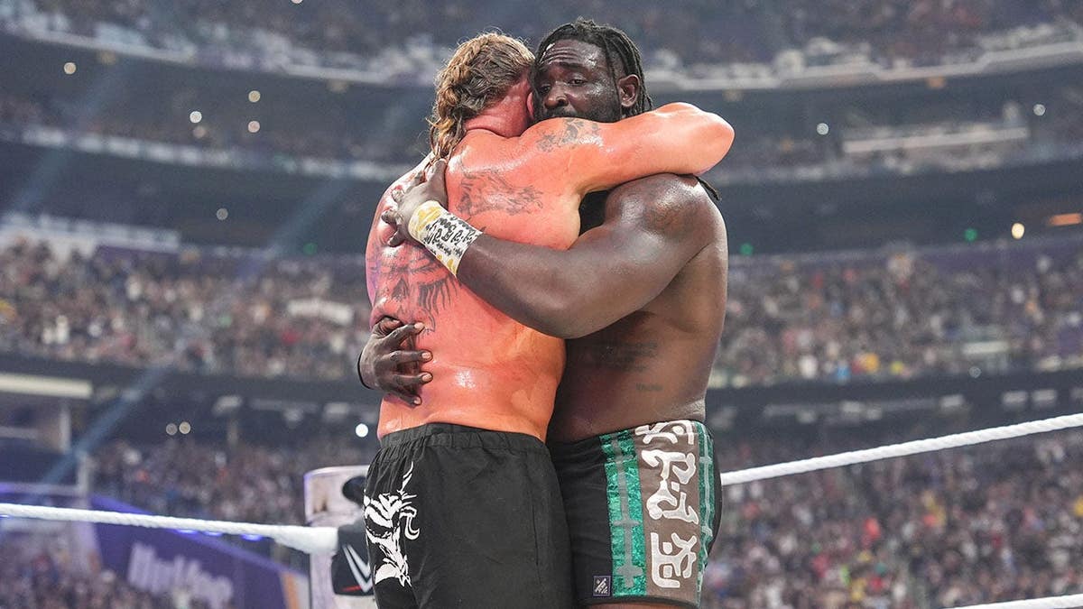 Brock Lesnar and Oba Femi hug in the ring during SummerSlam.