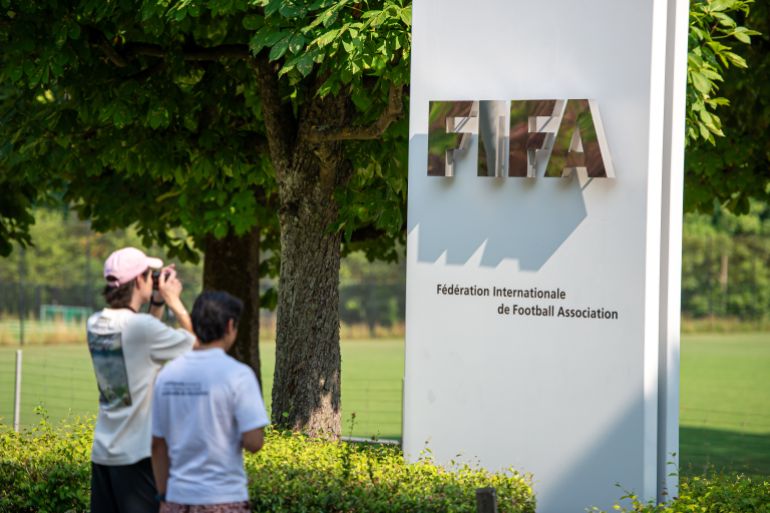 Football fans photograph a FIFA logo outside FIFA (Fédération Internationale de Football Association) global headquarters on July 30, 2026 in Zurich, Switzerland [Photo: Robert Hradil/Getty]