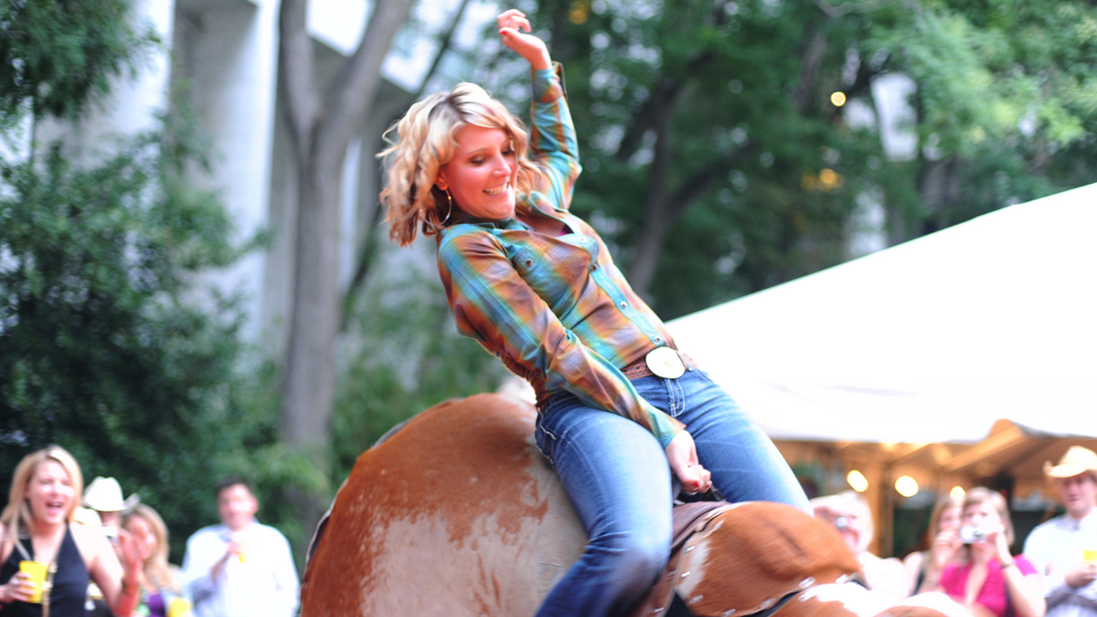 Megan Degenfelder, from the office of Rep. Cynthia Lummis, R-Wyo., rides a mechanical bull.