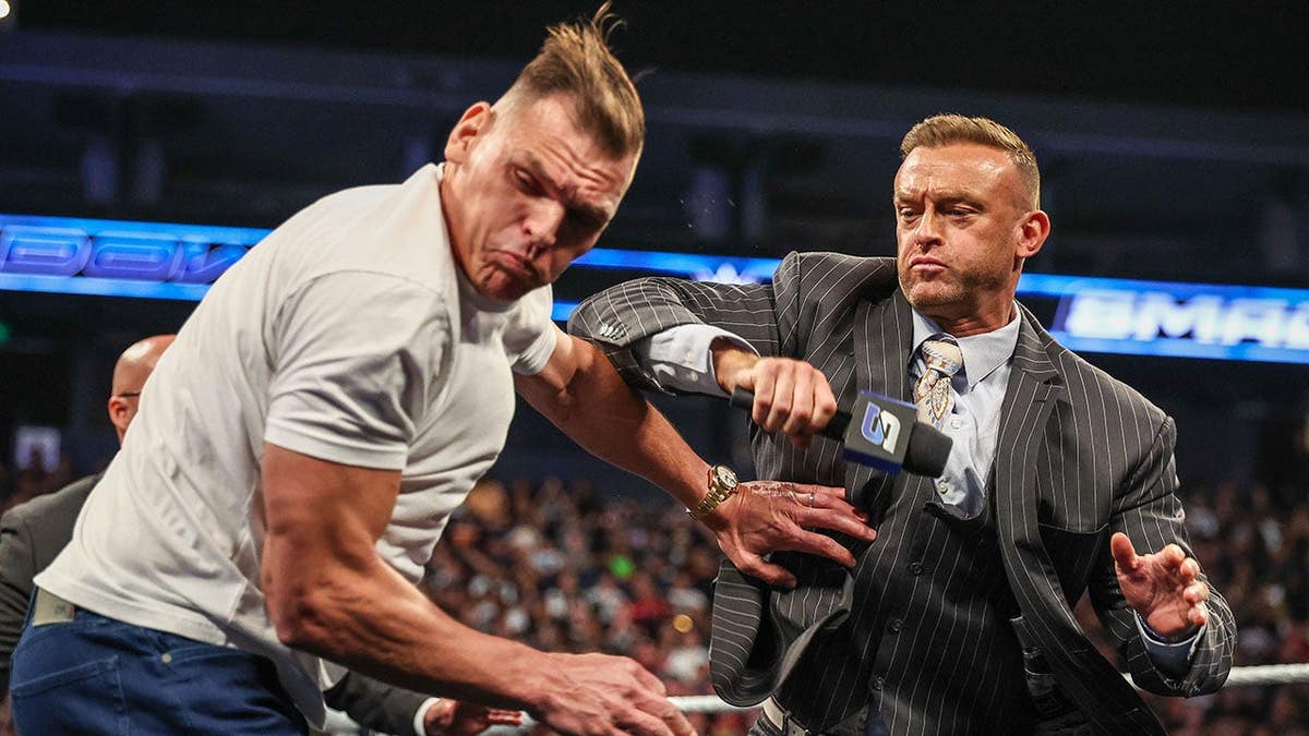 Nick Aldis attacks GUNTHER during a wrestling match at Oakland Arena.