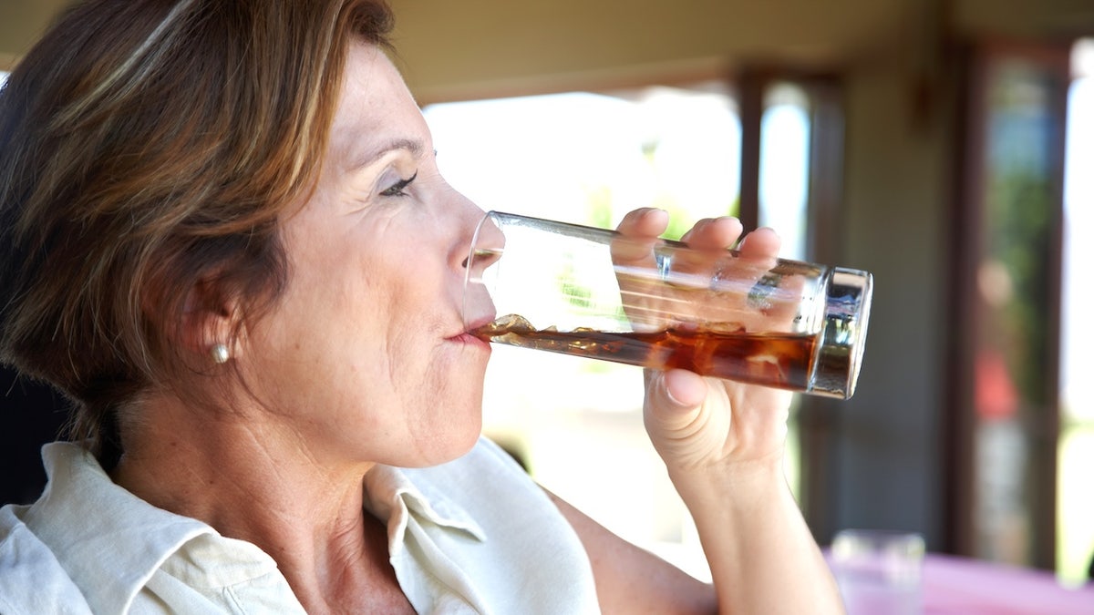 Older woman drinking soda
