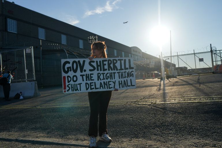 A protester holds a sign outside of Delaney Hall detention center, after a Salvadoran immigrant, Edwin Lopez-Cornejo, who was being held inside died on Saturday, in Newark, New Jersey, U.S., August 3, 2026. REUTERS/Ryan Murphy REFILE - CORRECTING SURNAME FROM "LOPEZ-CONEJO" TO "LOPEZ-CORNEJO".