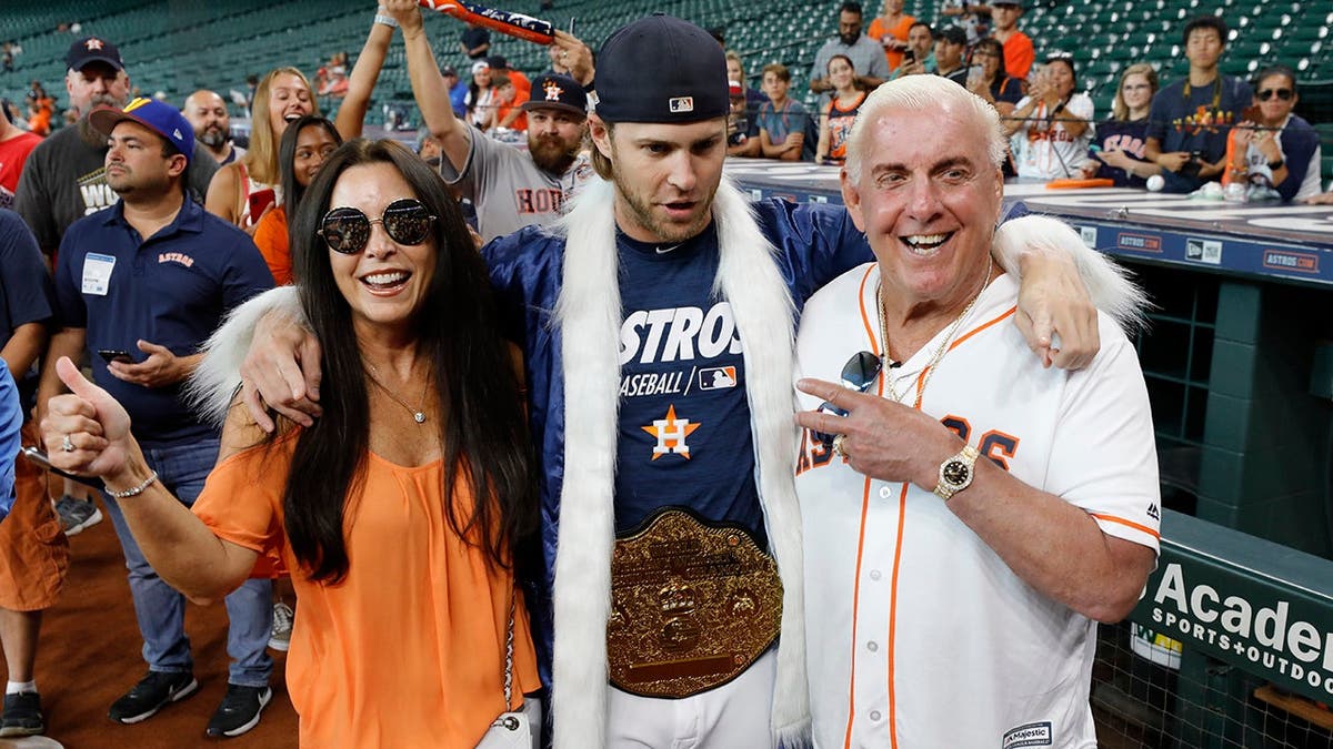 Ric Flair stands with Wendy Barlow and Josh Reddick at Minute Maid Park.