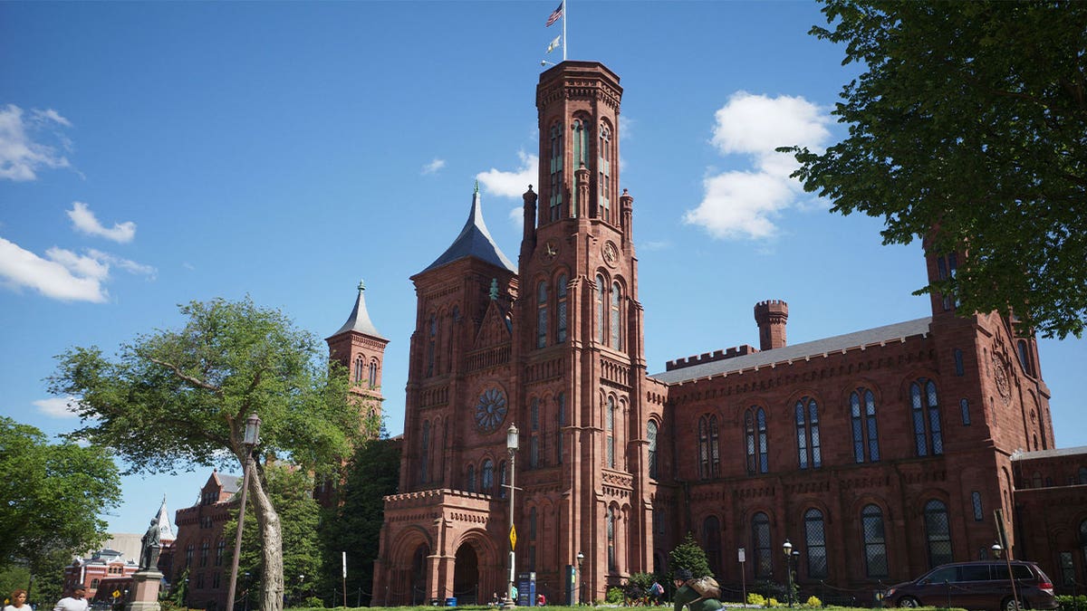 People walk on the National Mall near the Smithsonian Castle in Washington, D.C.