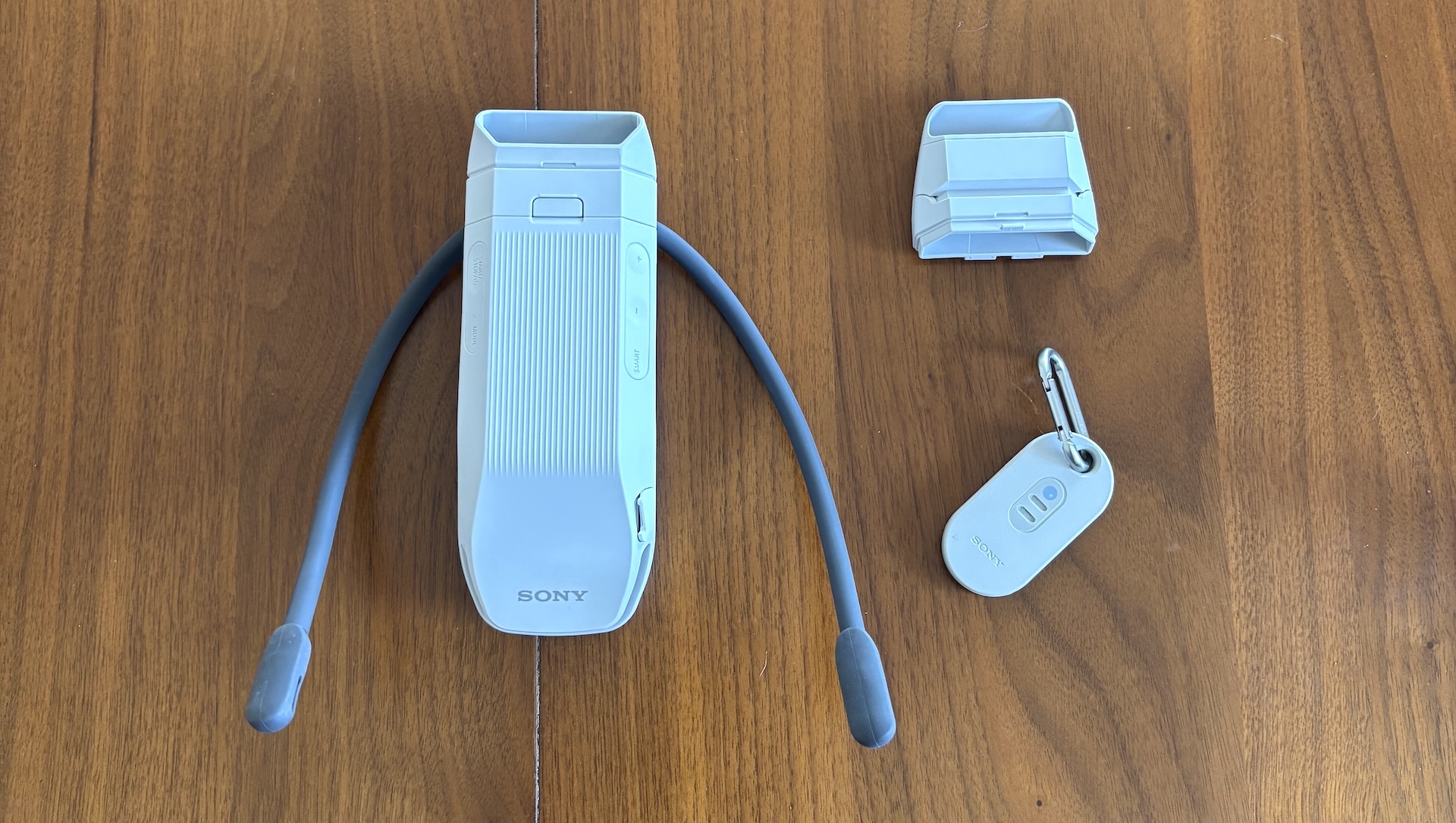 The Sony Reon Pocket Pro Plus next to the short air vent and sensor tag on a wood table.