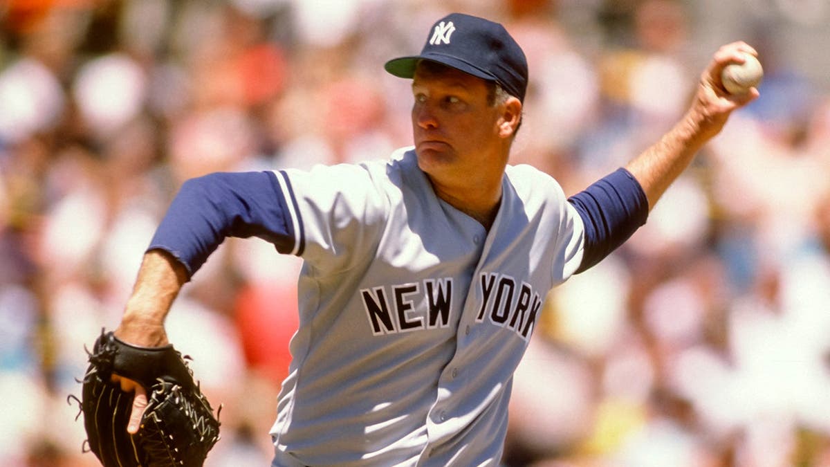 Tommy John pitches for the New York Yankees against the Oakland Athletics.