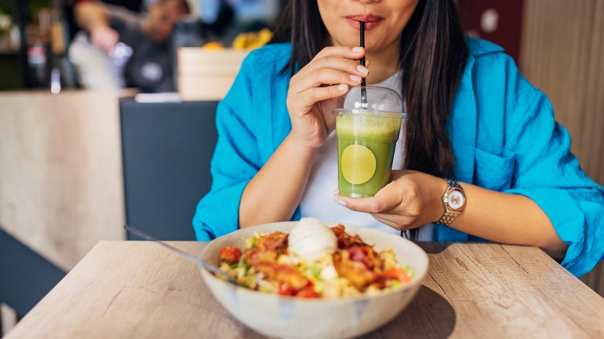 Woman eating salad and smoothie