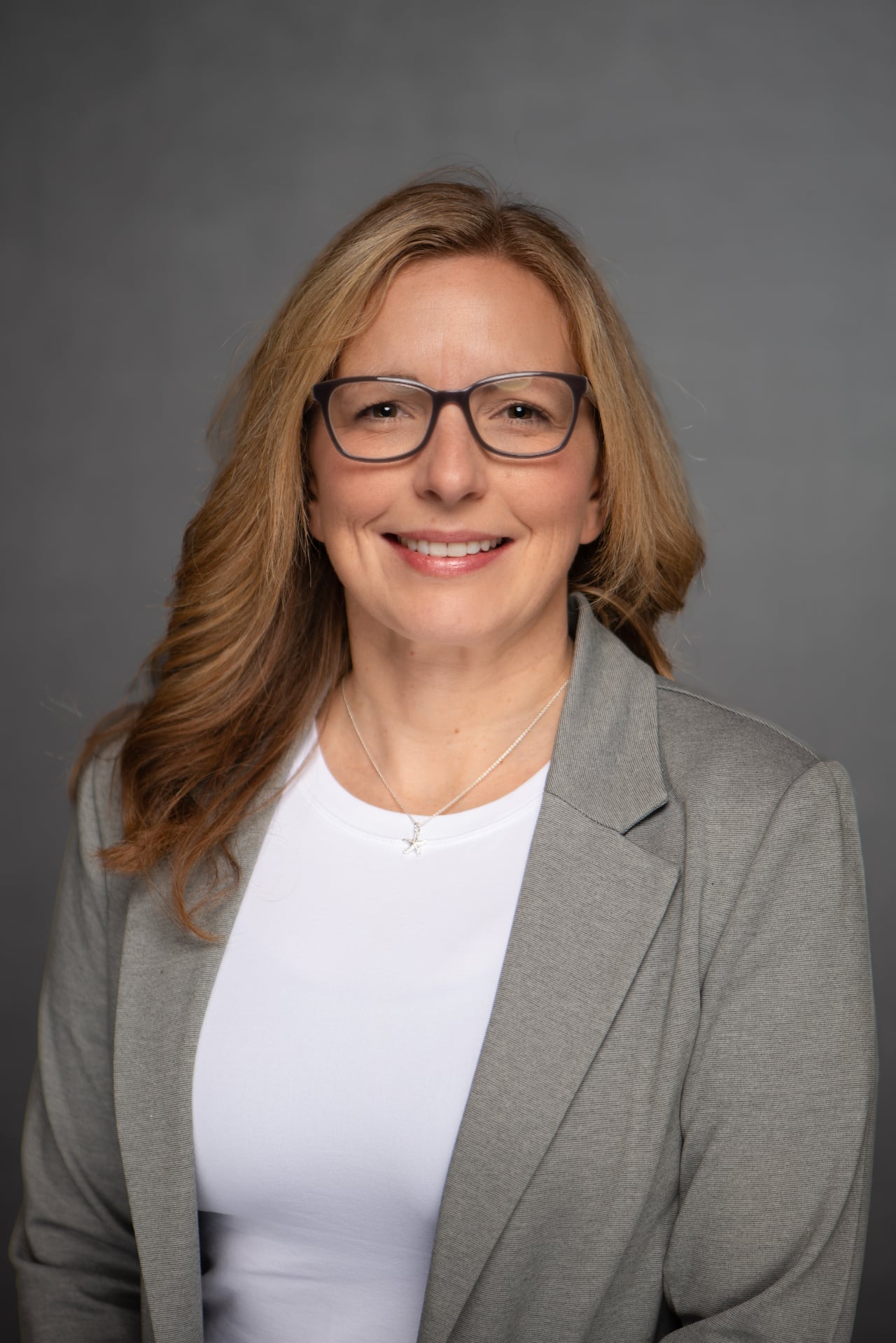 A woman smiles into the camera