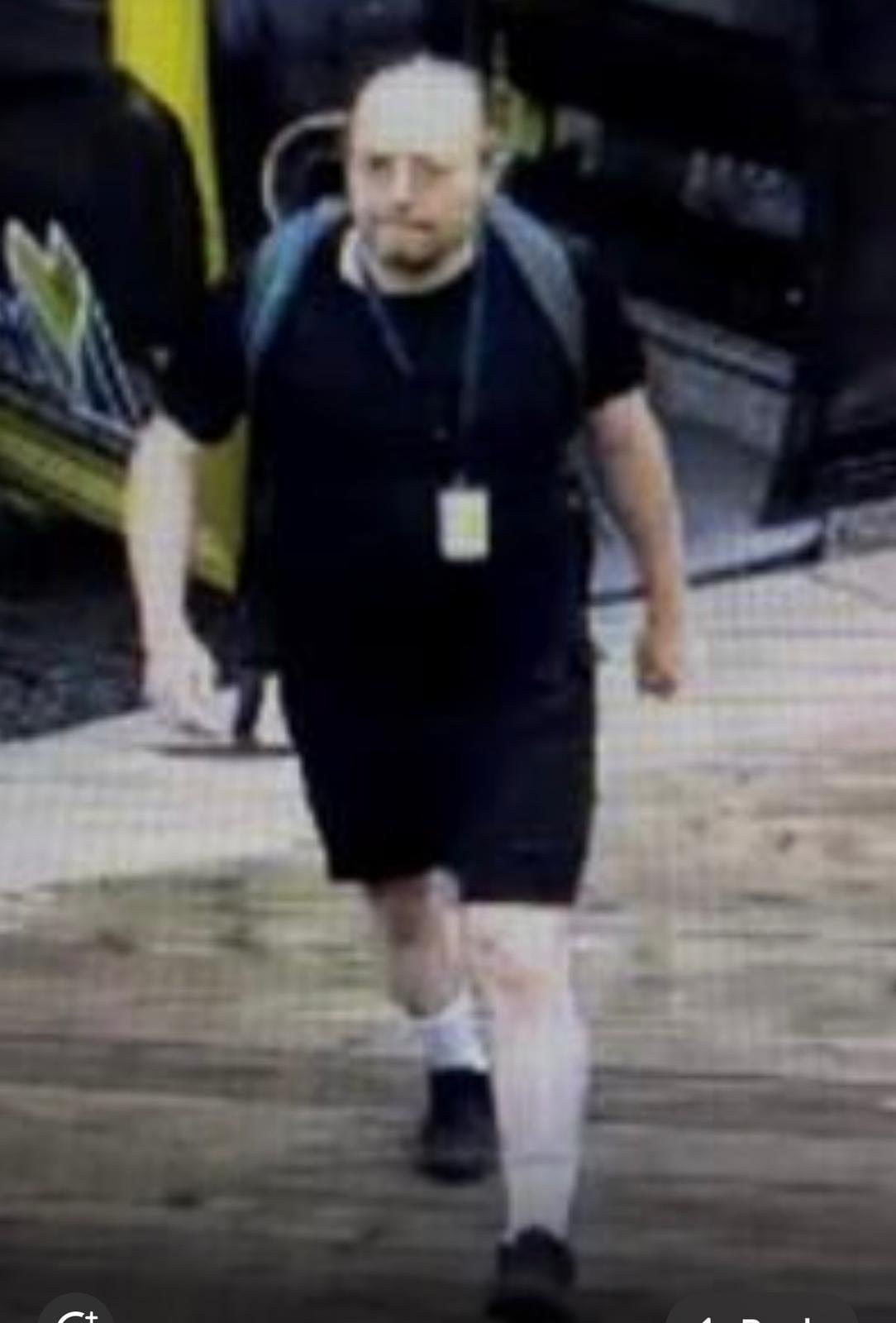 A man with a backpack in black clothing walks away from a gondola.