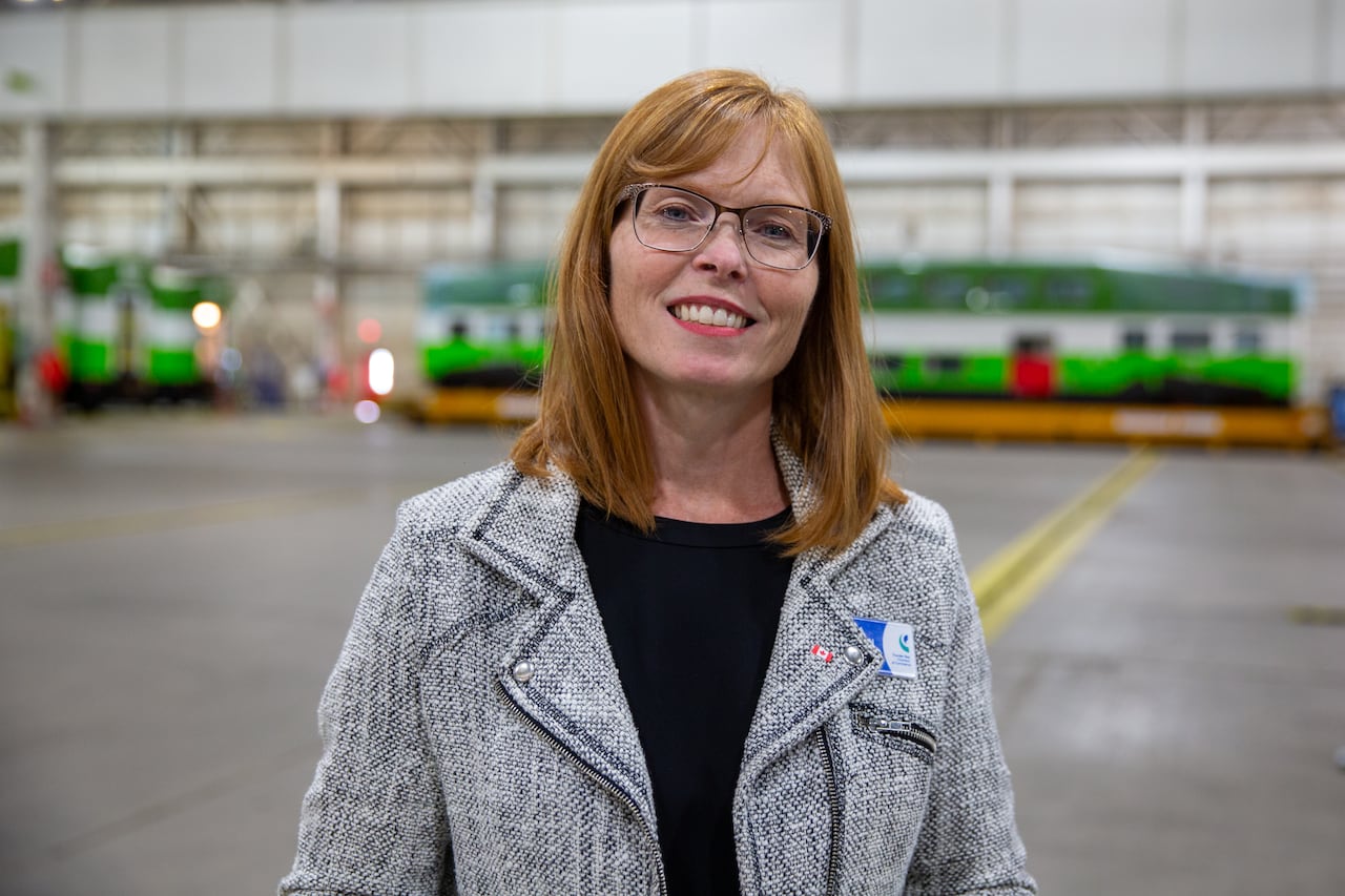 A person wearing a grey blazer is seen standing inside a plant.