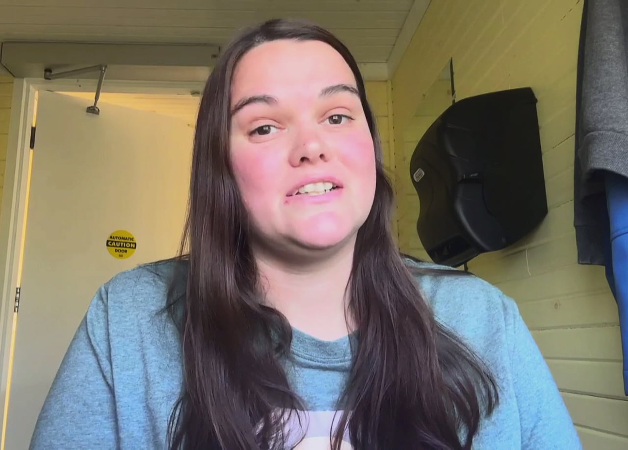 A woman is on a video call, with head and shoulders visible. She is indoors.