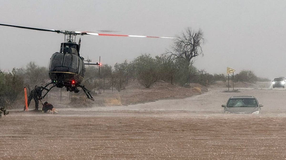 Helicopter conducts rescue of people stuck in stranded vehicle