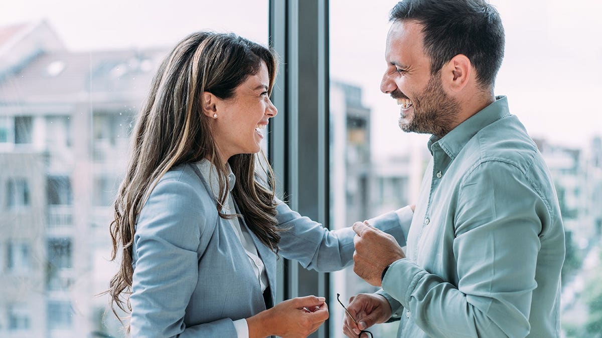 Two business colleagues discuss work in a modern office.